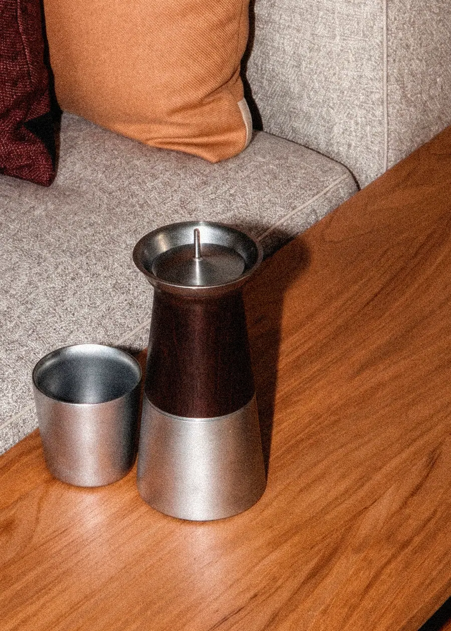 Primer plano de la cafetera Argo y su vaso sobre una mesa de madera
