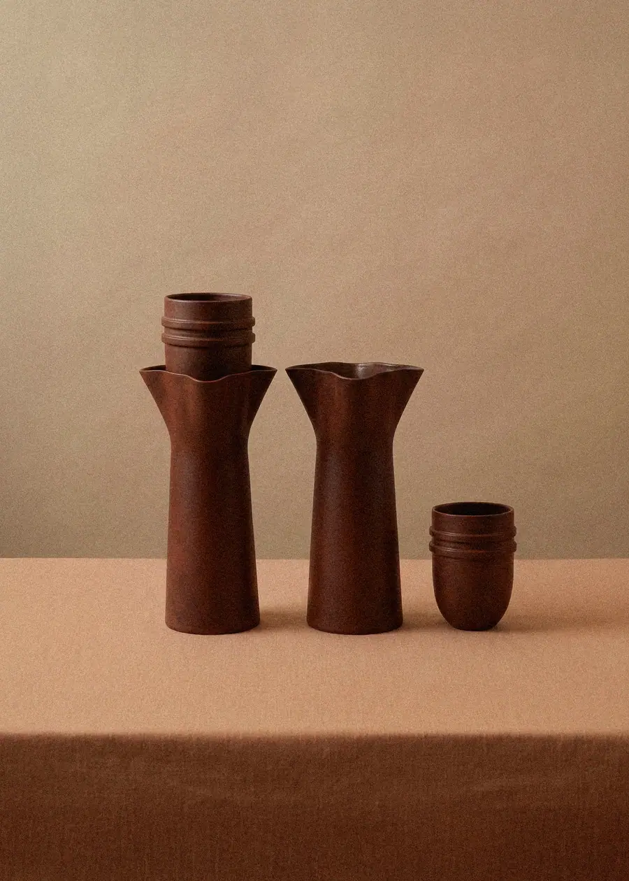 Familia de jarras y vasos de barro Canaleta sobre una mesa con mantel